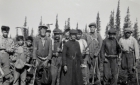 Workers and Catholic priest at a construction site