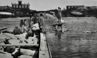 Men on small barge transporting bales