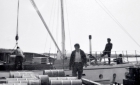 Cree labourers loading fuel drums