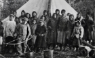 Young Cree women, boys and girls in front of tent