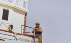 Cree man straddling the side of a schooner