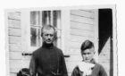 A Catholic priest with a Cree boy and girl