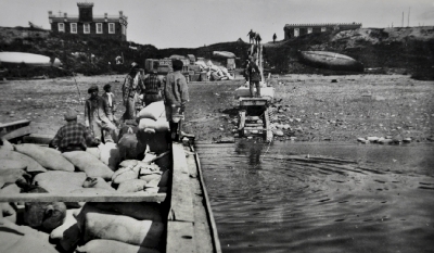 Men on small barge transporting bales