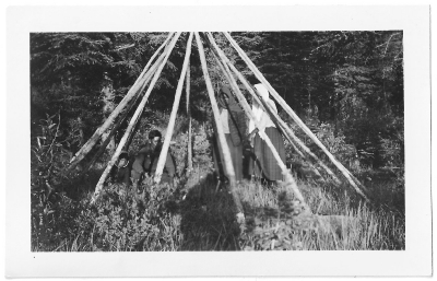 Men and women constructing a summer teepee